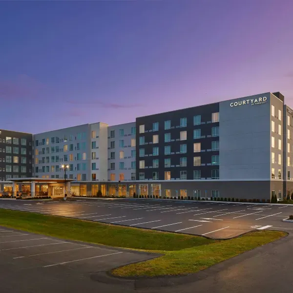 Courtyard Albany Airport exterior and parking area at dusk